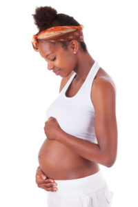 young pregnant black woman touching her belly
